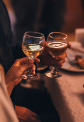 Close up of hands young couple clinking with glasses of champange at restaurant