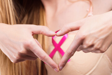 Woman with pink cancer ribbon on breast
