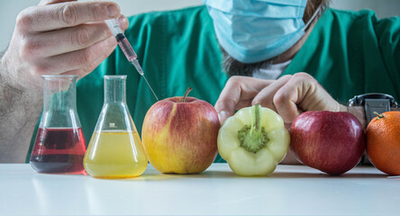 Biochemist working in farming laboratory analyzing gmo vegetable. Closeup of scientist biologist hands injecting organic apple with pesticides using medical syringe during microbiology experiment. - obrazy, fototapety, plakaty