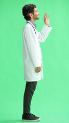 Fototapeta na wymiar male doctor in a white coat on a green background in profile
