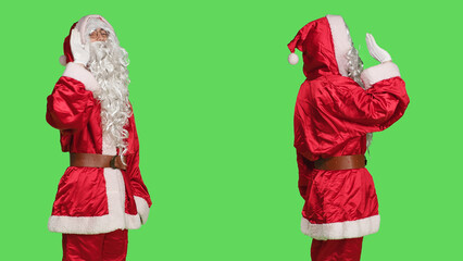 Person in santa claus suit wave hello on camera, acting joyful and confident over greenscreen backdrop. Festive seasonal character greeting people or saying goodbye, isolated template.
