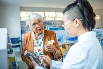 Senior woman customer consulting pharmacist about product in drugstore