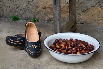 A pair of madreñas, typical clogs in Asturias, next to a basket full of apples, Gratila village,...
