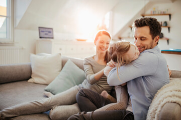 Happy young family on the sofa at home