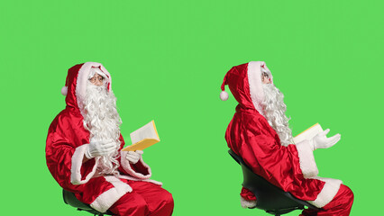 Saint nick reads poetry book in studio against isolated greenscreen backdrop, enjoying lecture of...