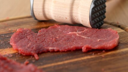 Dolly shot of Meat Tenderizer and Raw Steak.