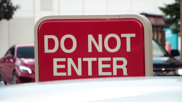 do not enter rectangle red and white sign with cars vehicles lined up behind moving toward sign with front ones pulling up and bicycle passing in front