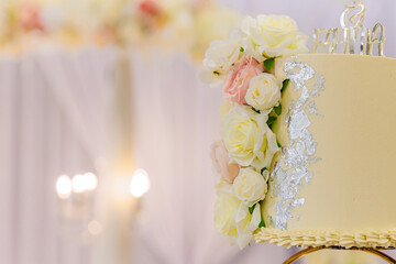 Beautiful creamy yellow wedding cake decorated with roses