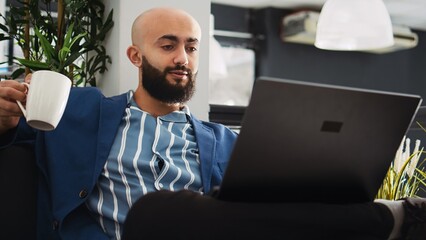 Business professional review analytics, looking at past online reports on laptop. Focused company...