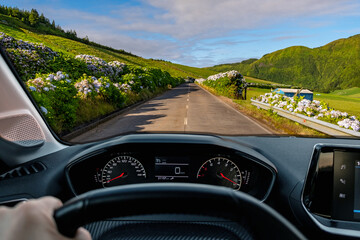 Driver view to the road with beautiful green landscape view from inside stoped car of driver POV of the road landscape. São Miguel island in the Azores, Portugal, Europe. - obrazy, fototapety, plakaty
