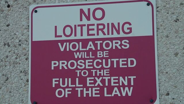 no loitering violators will be prosecuted to the full extent of the law writing caption text sign on wall, white and red