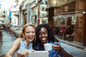 Friends Sharing a Laugh over Coffee at a Cafe