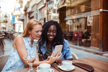 Friends Sharing a Laugh over Coffee at a Cafe