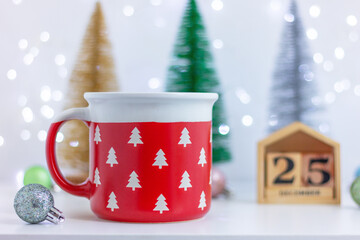 Christmas festive decor, calendar and red cup with pattern of white fir trees. decorations, celebration, winter holiday