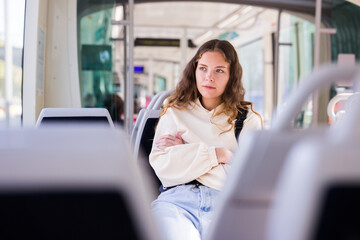 Young attractive lady, public transport passenger, enjoying her travel inside tram
