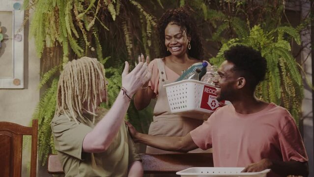 Happy young people complimenting each other after throwing away recyclables.