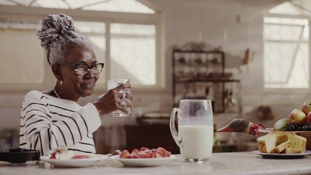 Beautiful lady drinking glass of milk in kitchen at home. Cinematic 4k.