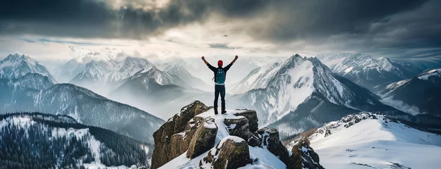Foto op Canvas Climber alpinist at the top of a snowy mountain in winter. Cliff covered with ice, man hiker standing at the peak of rock and celebrates the success. Mountaineer reaching the summit. © Igor Tichonow