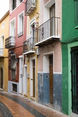 Fototapeta na wymiar Vertical shot of a street with colorful buildings in Alicante, Spain