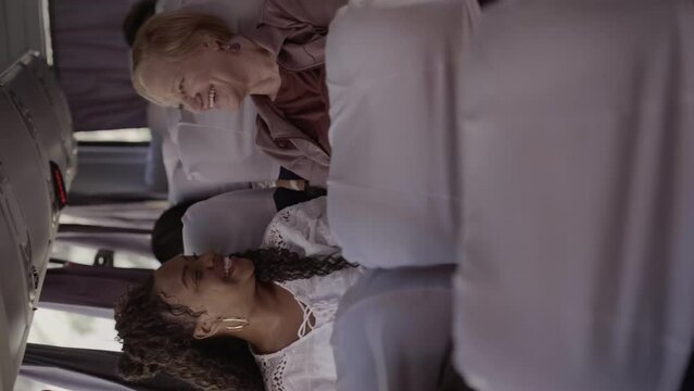Duas mulheres de idades diferentes, sentadas lado a lado em um onibus, conversando. Cinematico 4k. Video vertical.