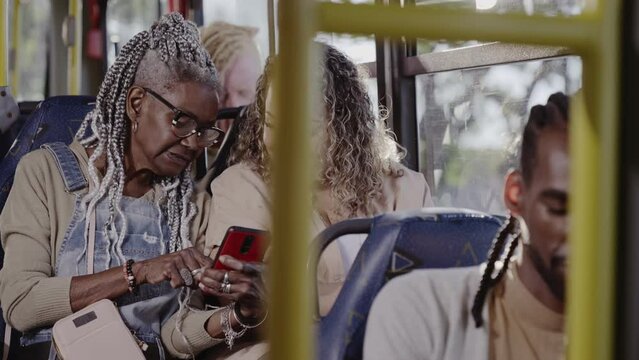 Mulher idosa mostrando algo em seu celular para uma mulher no onibus. Cinematico 4k.