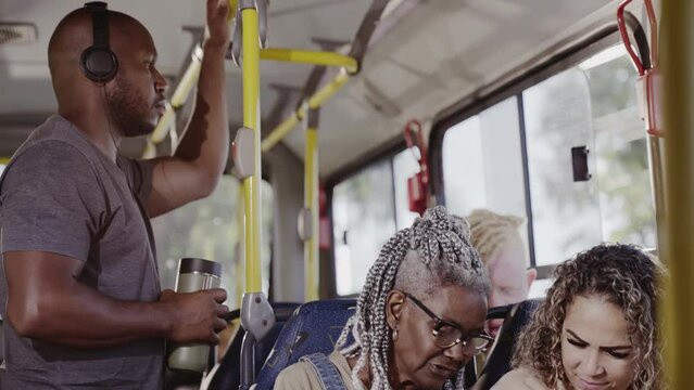 Passageiros multirraciais dentro do onibus em trajeto urbano. Cinematico 4k.
