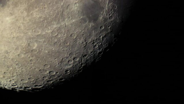 Natural surface of the Moon with meteorite craters. Real close-up shot of the Moon through an astronomical telescope