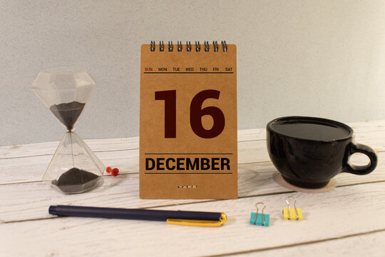 Cube shape calendar for December 16 on wooden surface with empty space for text