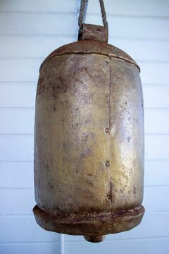 Vertical image of an old bell for cows bell on a white background