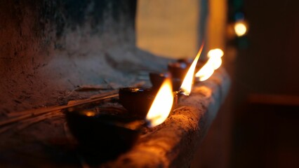 Closeup of row of burning candles on stone wall of a church