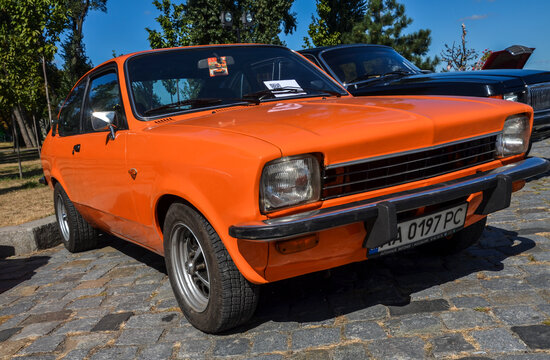 Orange two-door coupe subcompact car Isuzu Gemini 1st gen (PF50), 1978 which is an analogue of the Opel Kadett displayed at the exhibition of retro cars
