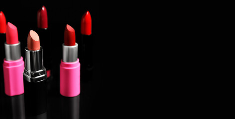 Obraz premium Many lipsticks on black background with space for text