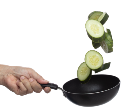 Cucumber fly fall in pan, green fresh vegetable cucumber cut chop slice. Organic fresh vegetable with eaten leaf of long cucumber, close up texture. White background isolated freeze motion high speed