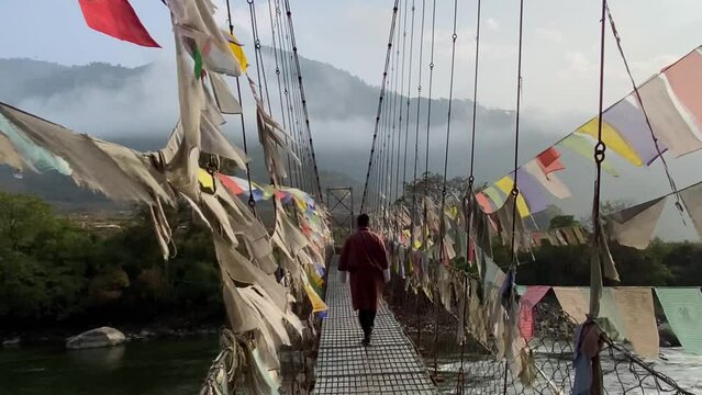 Colorful Buddhist prayer flags on the famous tourist attraction Punakha Suspension Bridge on the river next to the Punakha Dzong