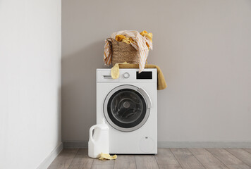 Basket with dirty clothes on washing machine in laundry room - obrazy, fototapety, plakaty