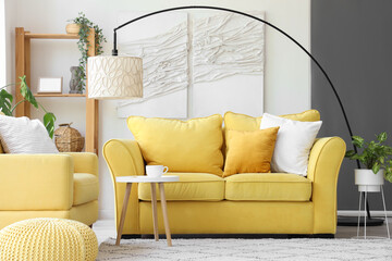 Interior of light living room with yellow sofa and armchair