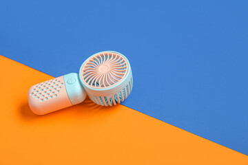 Small new electric fan on color background - obrazy, fototapety, plakaty