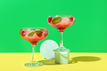 Glasses of fresh raspberry mojito on colorful background