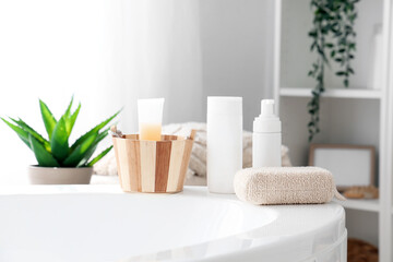 Fototapeta na wymiar Shower gel, shampoo and sponge on bathtub