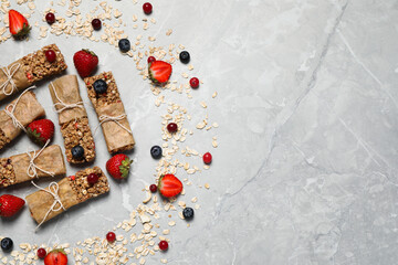 Tasty granola bars and ingredients on light grey marble table, flat lay. Space for text