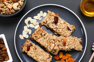 Tasty granola bars on grey wooden table, flat lay
