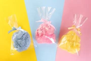 Poster Packaged sweet cotton candies on color background, flat lay © New Africa