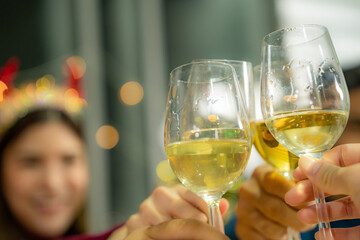 woman holding a champange glass. beautiful asian women toss white wine of champange in party indoor chhristmas event.