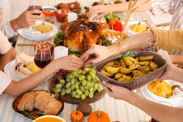 Young woman putting baked potato on dining table for Thanksgiving Day, closeup