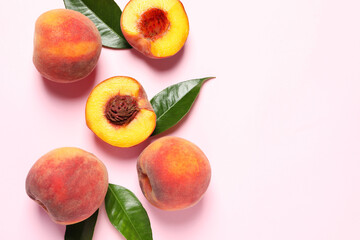 Cut and whole fresh ripe peaches with green leaves on pink background, flat lay. Space for text