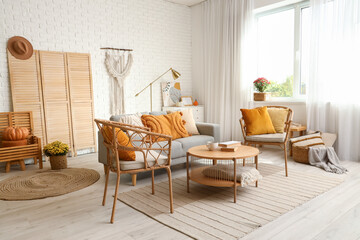 Interior of stylish living room with armchairs, grey sofa and wooden coffee table