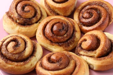 Plate with many tasty cinnamon rolls, closeup