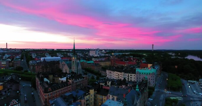 Aerial Forward Shot Of Oscar Church Amidst Buildings Against Sky During Sunset - Stockholm, Sweden