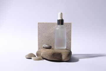 Composition with bottle of cosmetic serum on white background