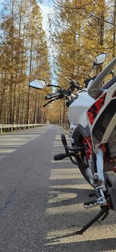 Vertical Of The Side Of A Sports Motorcycle Parked On An Empty Road Shot From Behind